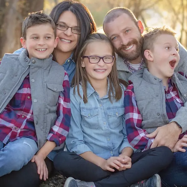 A family of five sitting together outdoors.
