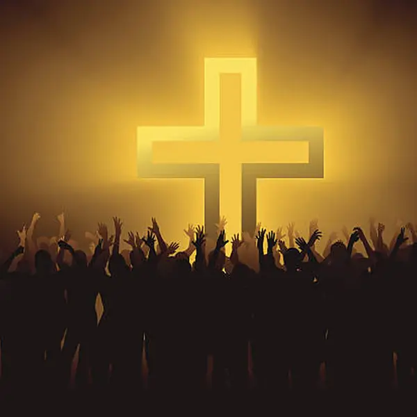 A lit cross above a crowd of silhouetted worshippers.